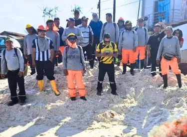 Obreros de construcción con su uniforme sobre montículo de arena en obra paralizada